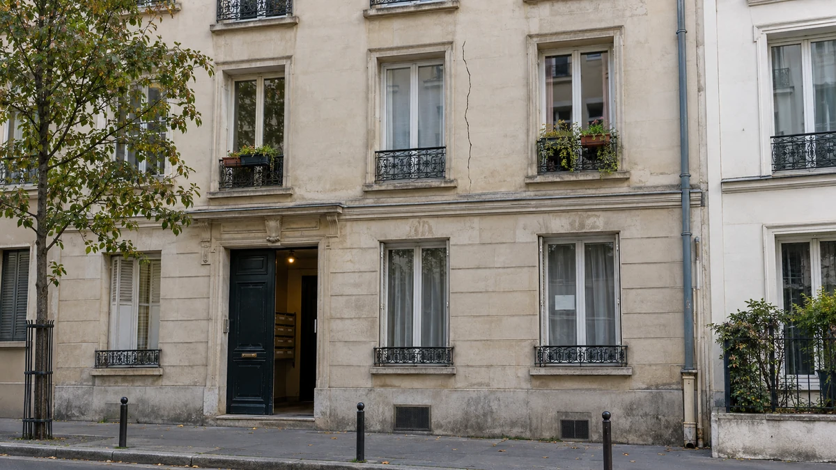 Façade d'un immeuble locatif francilien avec une fissure fine visible et une affichette à louer discrète