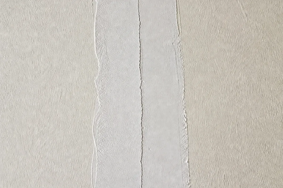 Le même rebouchage quelques mois plus tard, fendu en son milieu par la fissure qui a repris à travers l'enduit et la peinture