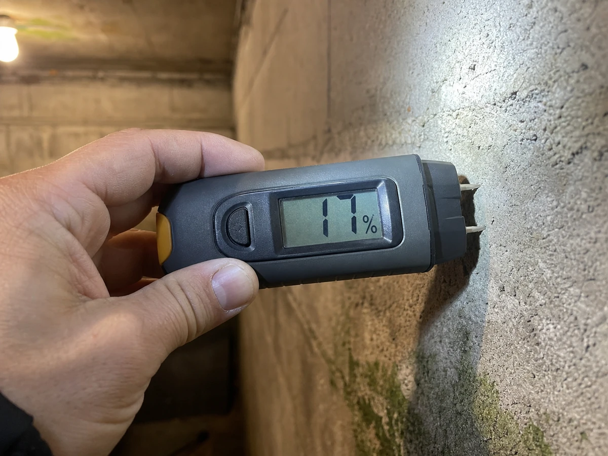 Humidimètre à pointes mesurant le taux d'humidité d'un mur en sous-sol