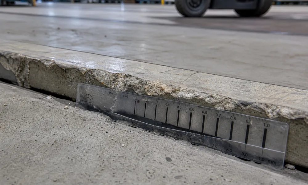 Détail d'un joint de dallage industriel fissuré mesuré par un expert Expert Fissure IDF au fissuromètre