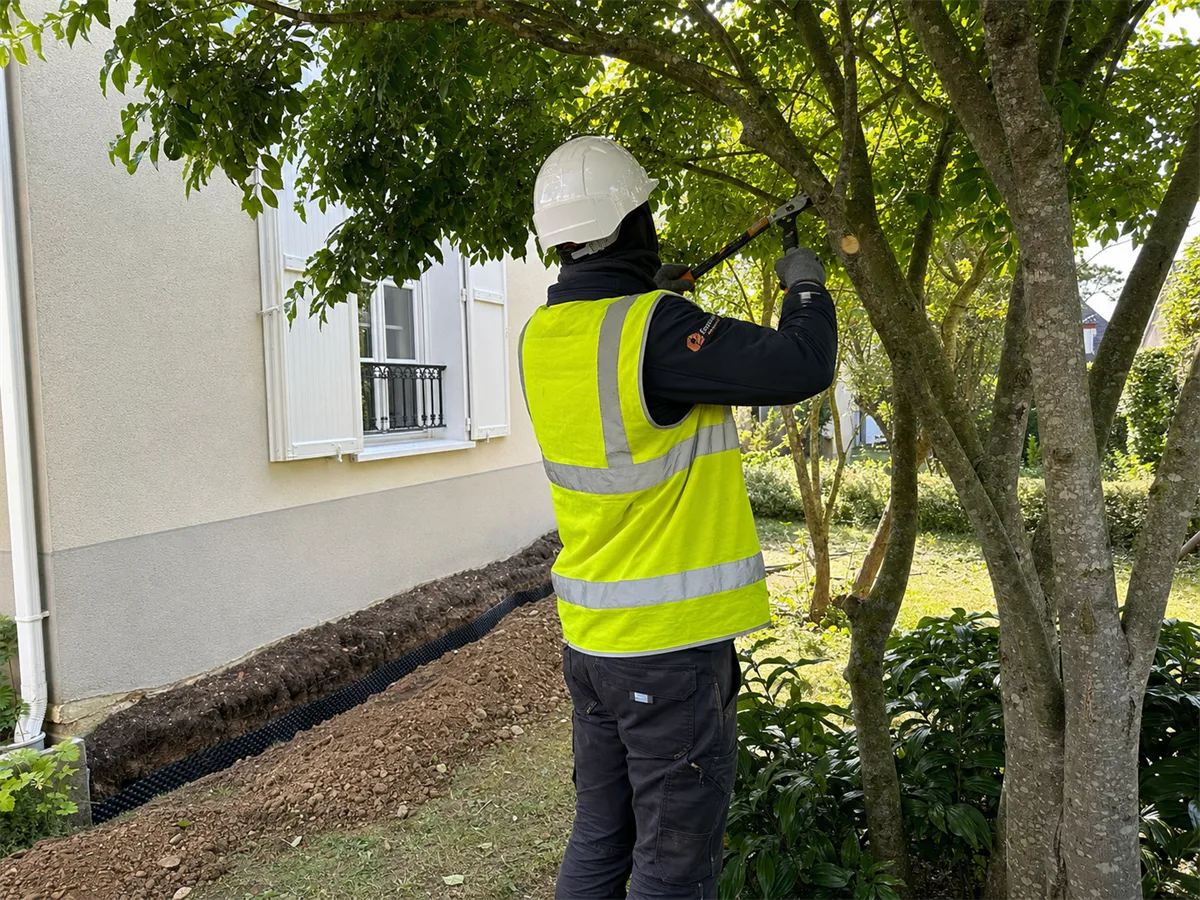 Expert Expert Fissure Île-de-France posant un écran anti-racines rigide dans une tranchée entre un arbre et une maison
