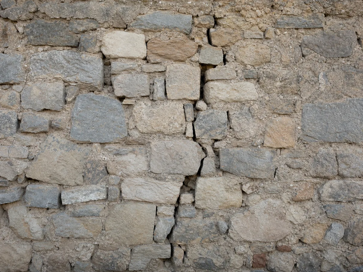 Mur en pierre avec fissure traversante et traces d'humidité, avant injection de résine