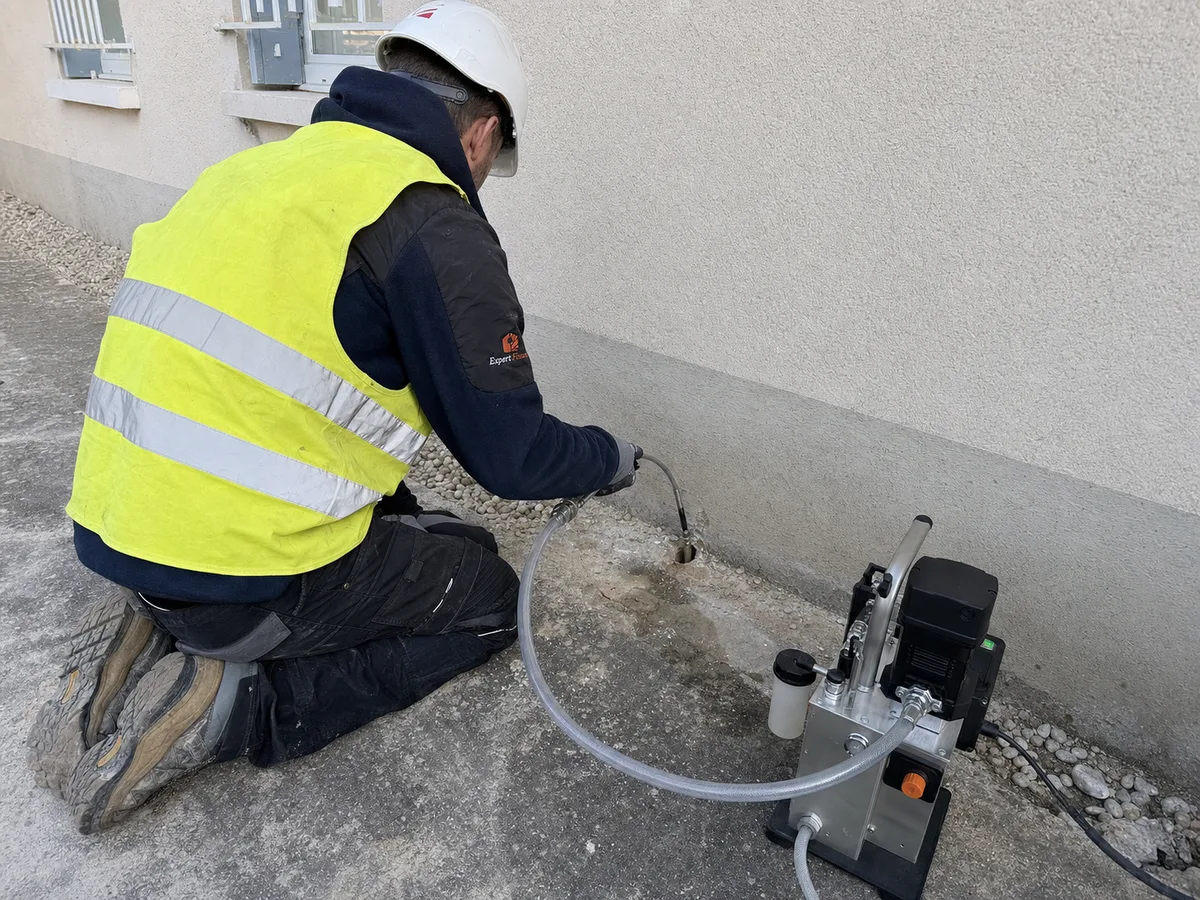 Expert Expert Fissure Île-de-France injectant de la résine expansive sous une fondation avec suivi de nivellement